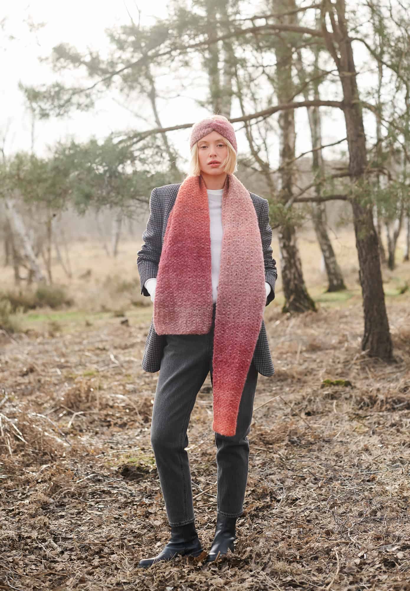 Frau trägt gestricktes Stirnband und gestrickten Schal in Rosa- und Orangetönen: Modell 34 aus Lovewool No. 21
