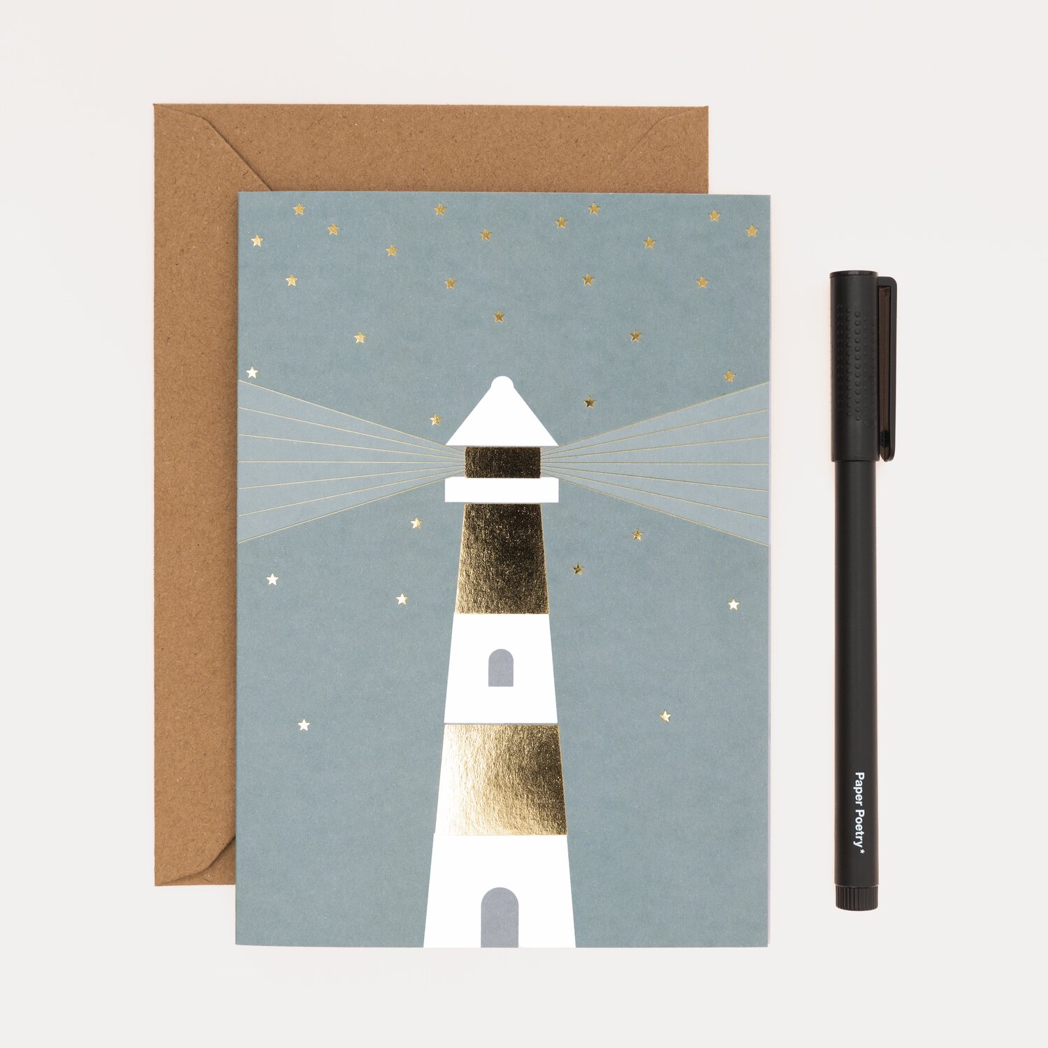 Paper Poetry Kartenset Leuchtturm, 20-teilig, zeigt einen stilisierten Leuchtturm auf blauer Karte mit goldenen Akzenten, inklusive braunem Umschlag.
