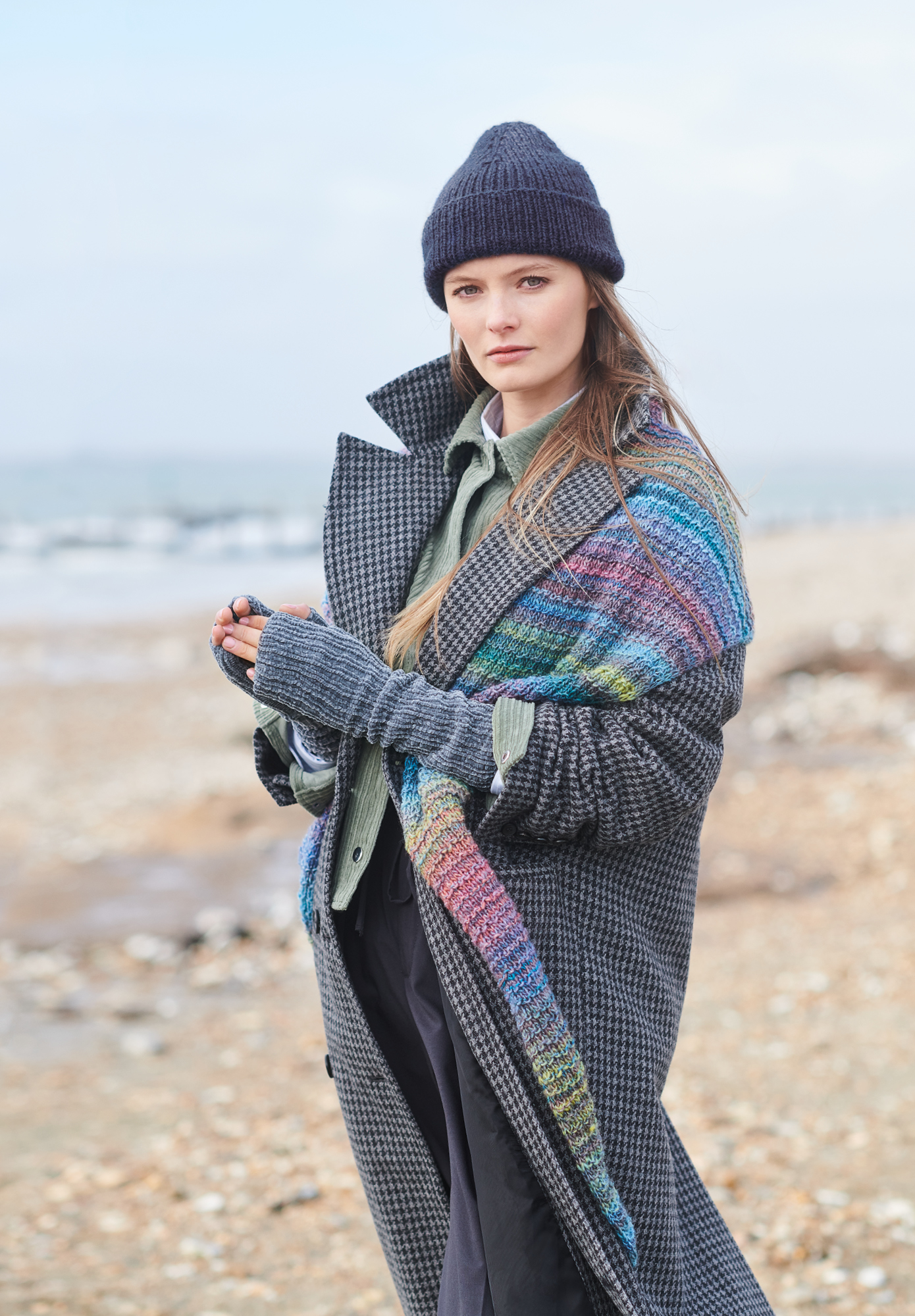Frau trägt gestricktes Dreieckstuch mit buntem Farbverlauf: Modell 34 aus Lovewool No. 19