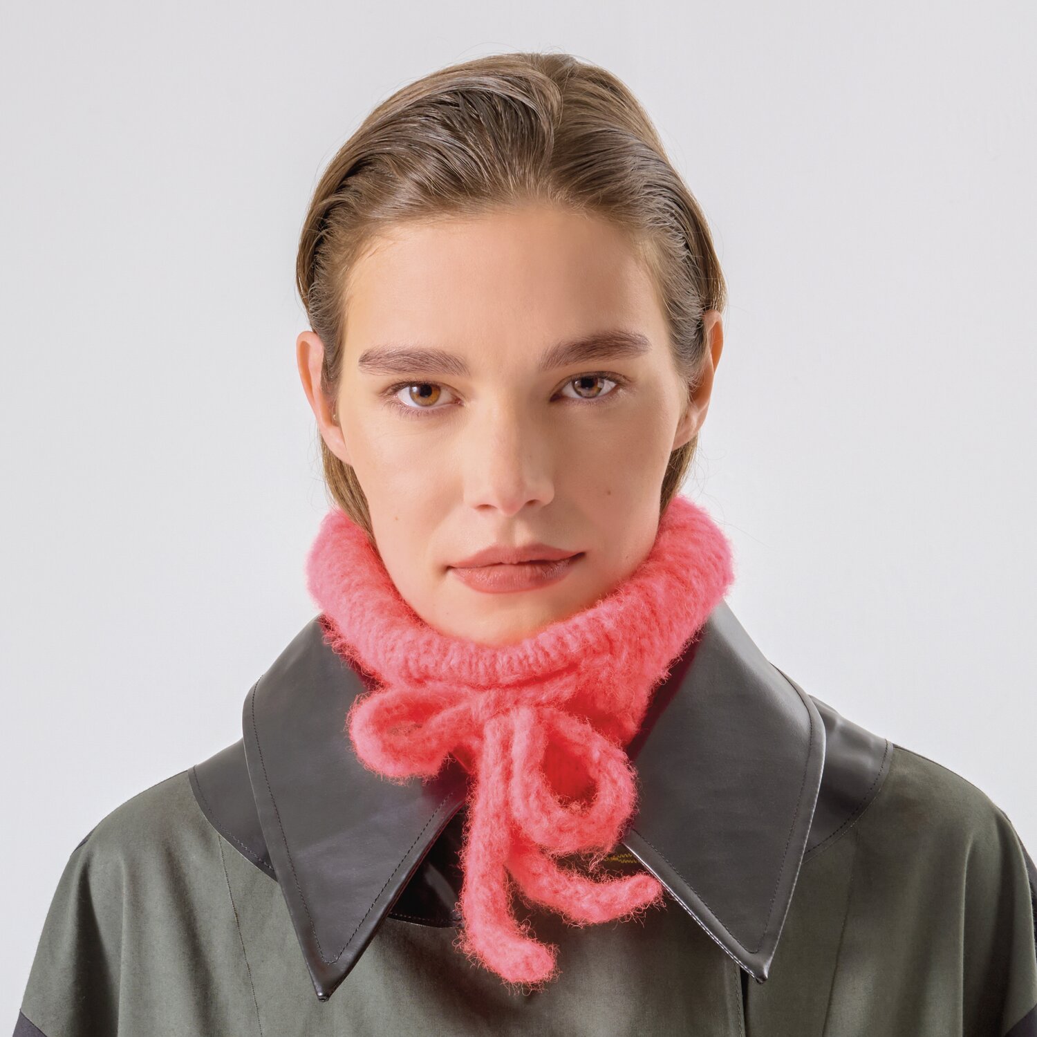 Strickset Kragen Modell 20b aus Made by Me No. 21 von Rico Design Strickset Kragen Modell 20b aus Made by Me No. 21: Frau trägt pinken Strickkragen über dunklem Mantel.