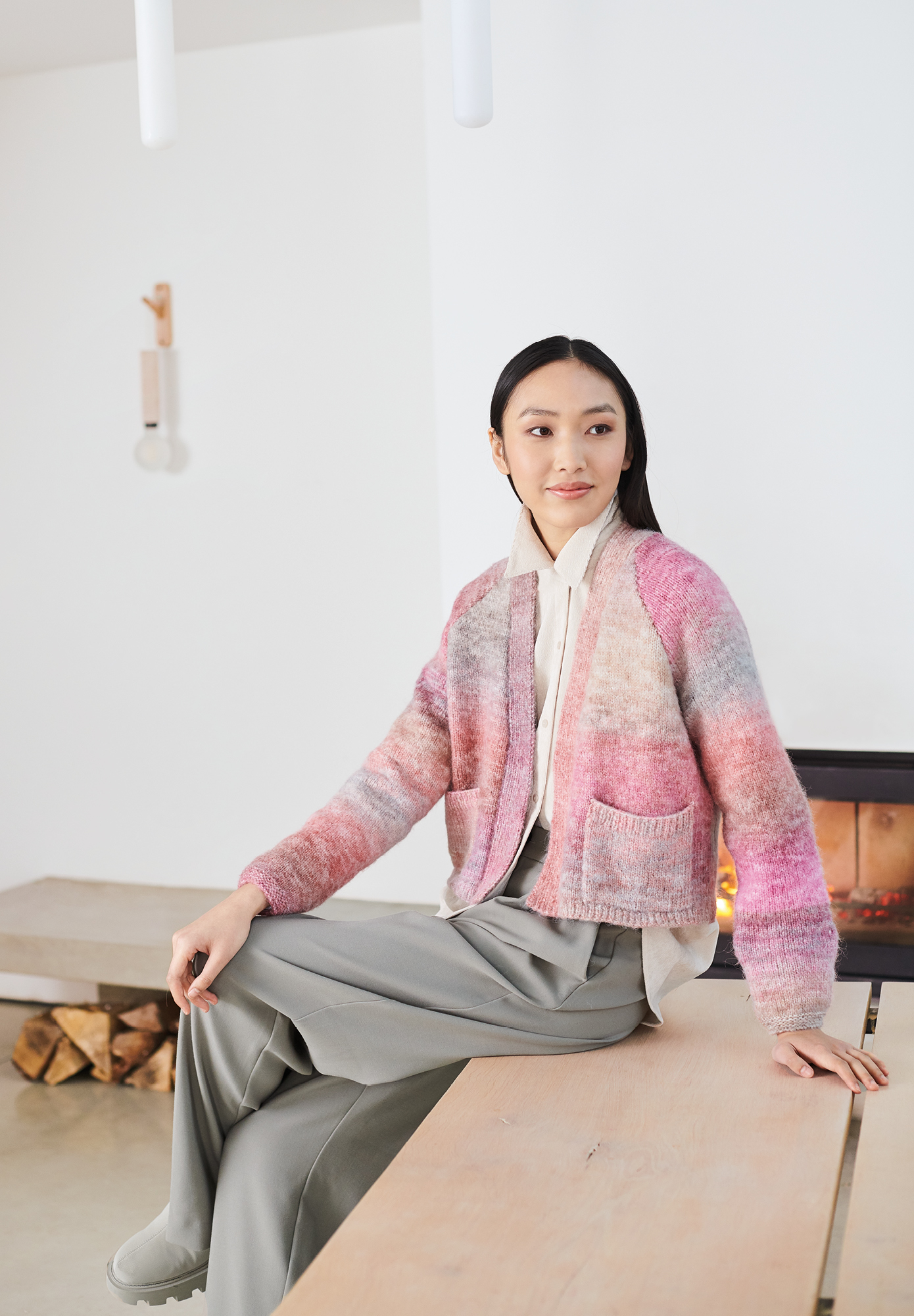Frau trägt gestrickte Jacke mit Rosa Farbverlauf: Modell 12 aus Lovewool No. 19