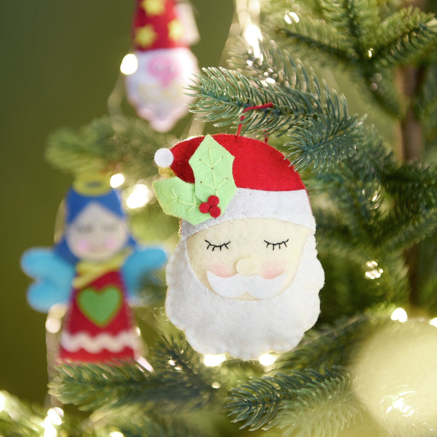 Aufhänger Filz-Engel mit Herz 10,5x8x1,7cm Farbe Rot-Blau von Rico Design Aufhänger Filz-Santa mit Ilex Rot/Weiß: Weihnachtlicher Filzanhänger in Rot und Weiß, dekoriert mit Ilexblättern, am Weihnachtsbaum.