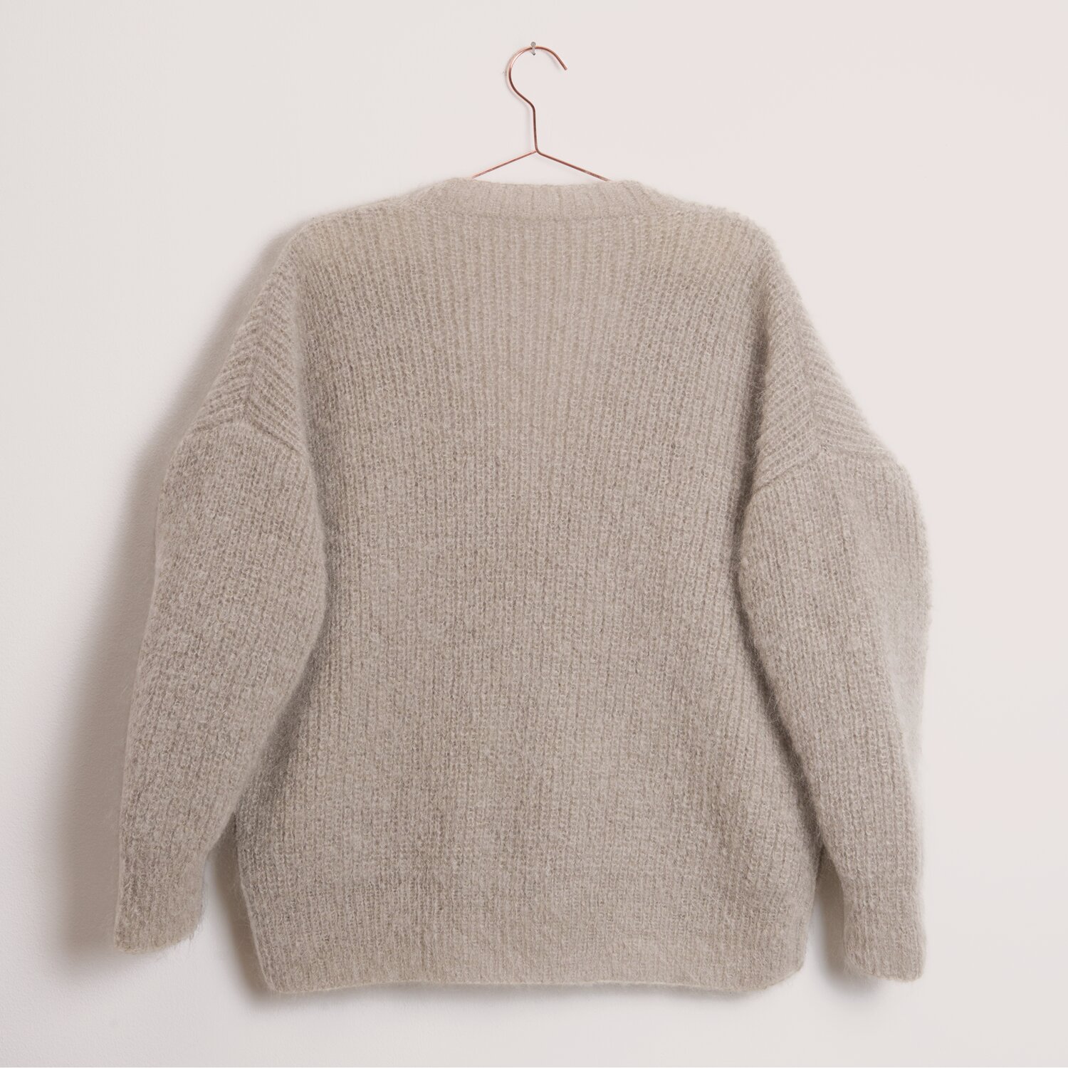 Fashion Mohair Merino aran, Rico Design, Strickpullover aus weichem Garn, Rückansicht in hellem Naturton, lässige Passform, präsentiert auf zartem Metallkleiderbügel
