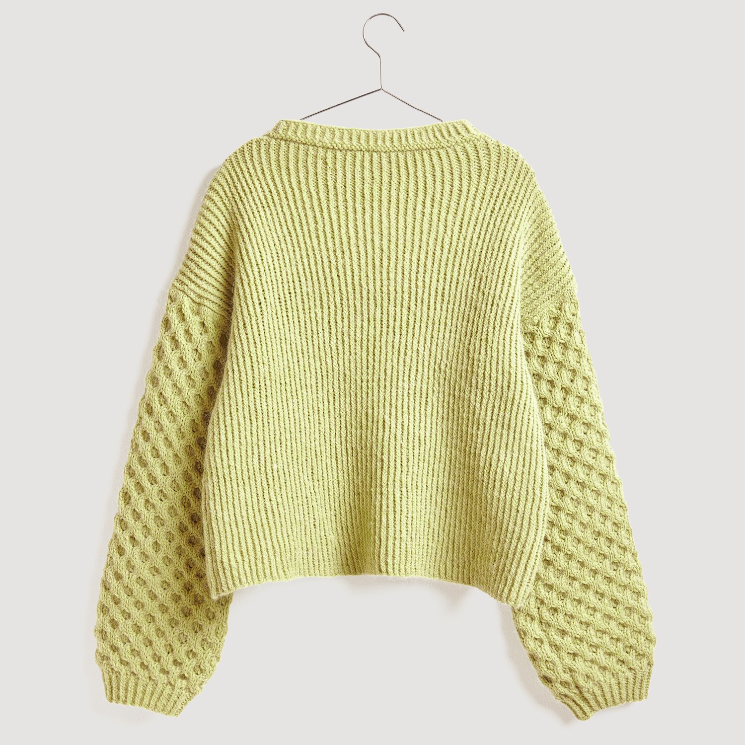Soft Alpaca 50g 125m Farbe Zitrone von Rico Design Soft Alpaca Pullover in Zitronengelb mit strukturierten Ärmeln, präsentiert auf einem Kleiderbügel.