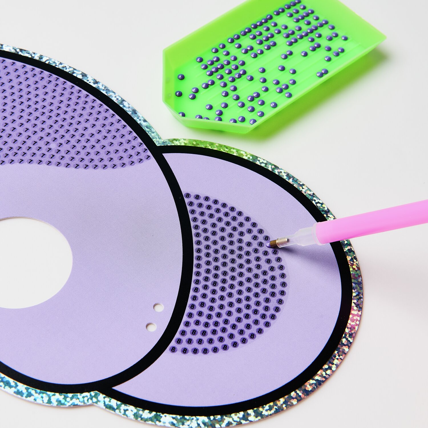 Diamond Painting Masken Tiere, 52-teilig. Lila Maske mit Glitzersteinen und grünem Tablett.