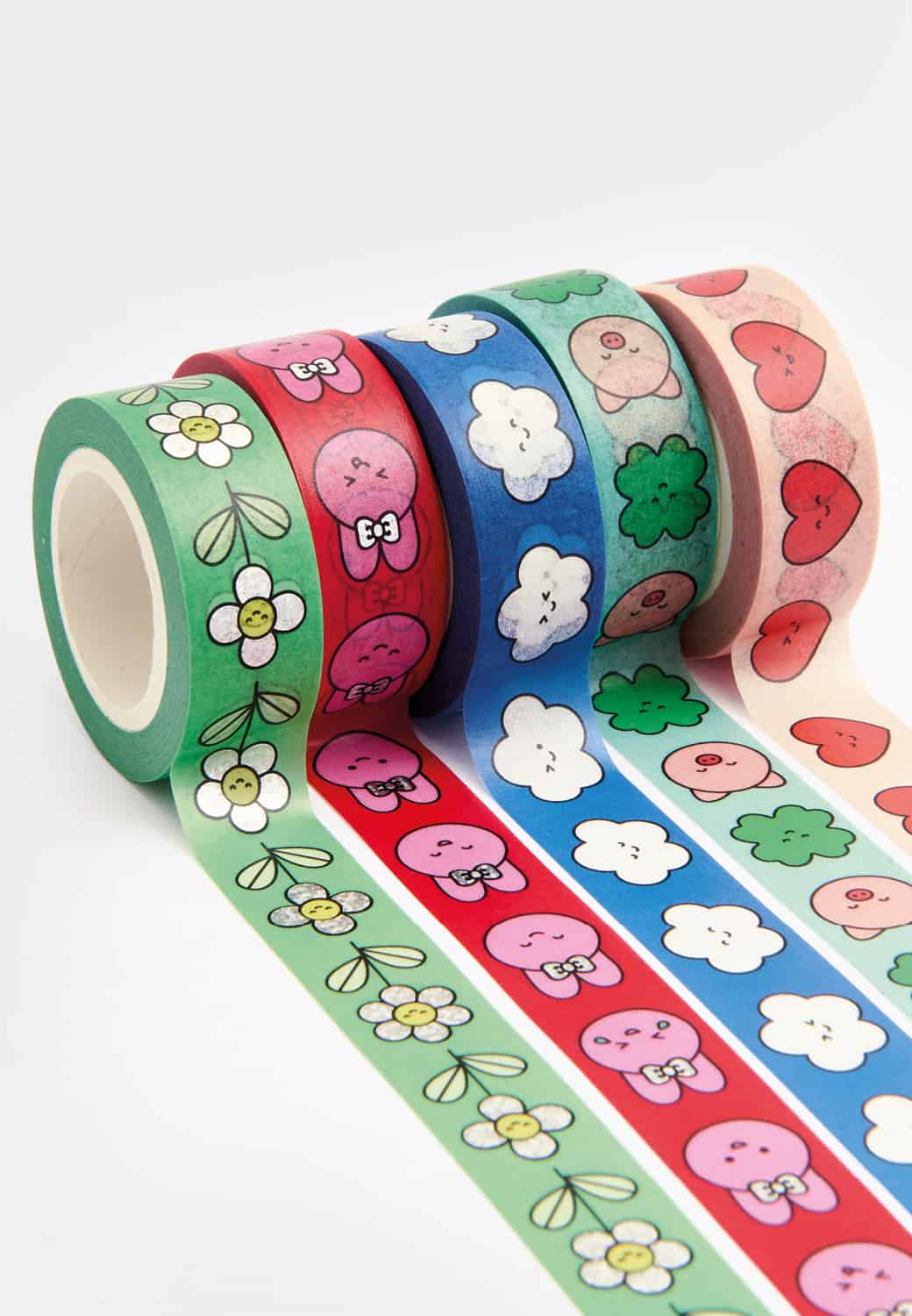 Tape Rollen mit bunten Illustrationen liegen ausgerollt auf hellem Hintergrund.