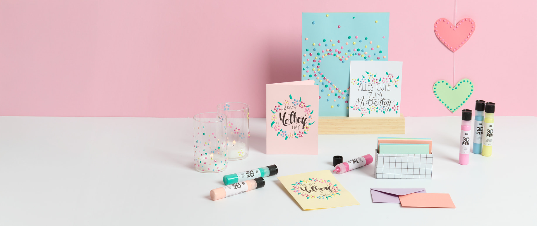 Muttertagskarten sind mit 3D Pens gestaltet und sind vor einer rosa Wand aufgestellt. 3D Pens und Umschläge umgeben die Karten dekorativ.