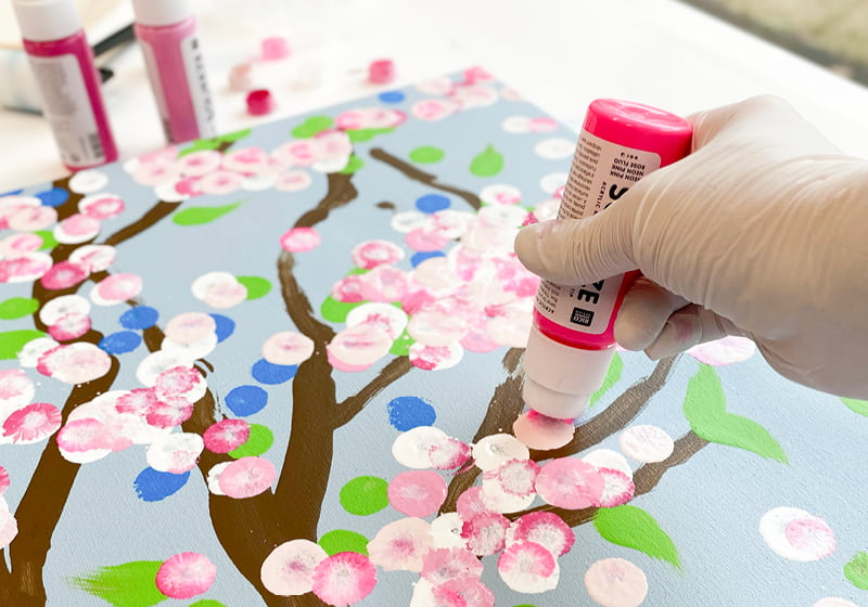  Eine Leinwand mit abstrakten Kirschblüten wird mit Squeeze Marker bemalt