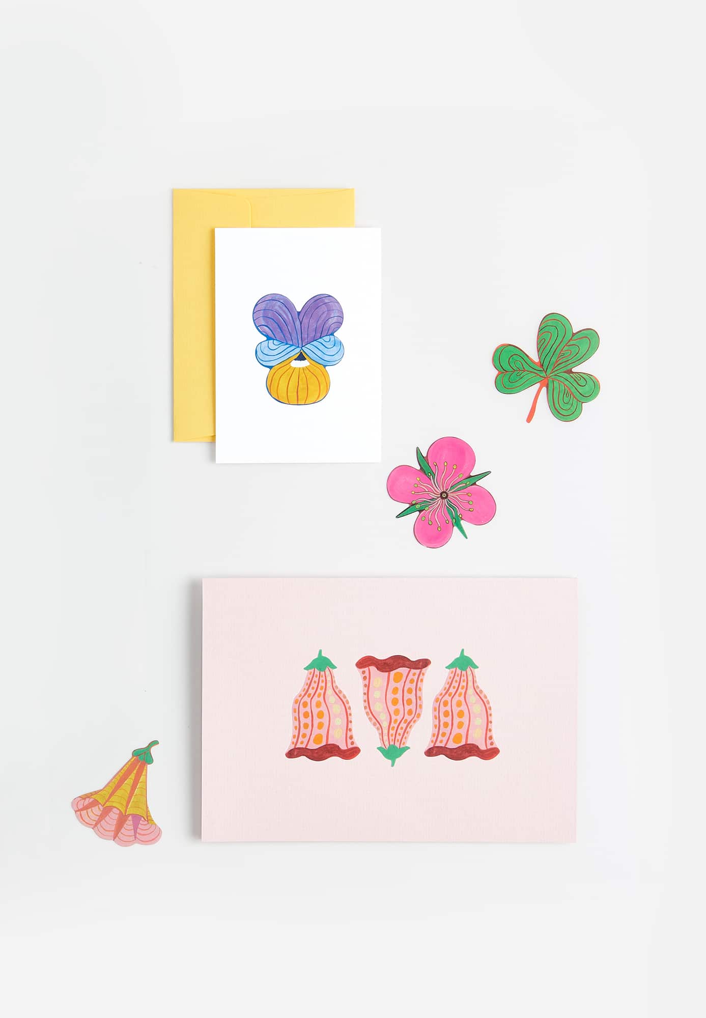 Zwei Karten umgeben von und mit Blumen-Stickern verziert auf grauem Hintergrund