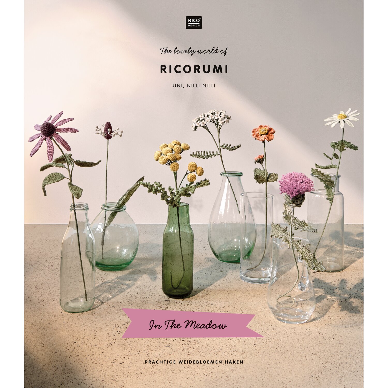 Ricorumi In the Meadow Häkelbuch von Rico Design mit gehäkelten Wiesenblumen in Glasvasen, dekorativ arrangiert auf hellem Untergrund für kreative Dekoideen