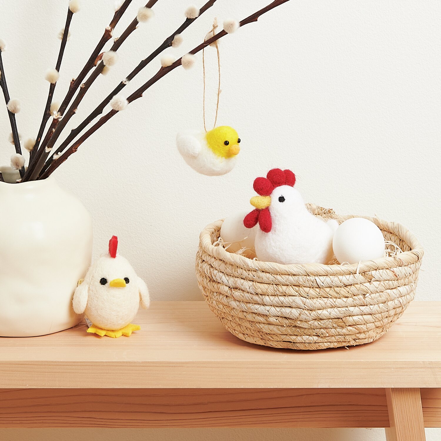 Aufhänger Filz-Huhn Weiß: Dekoratives Filz-Huhn in Weiß von Rico Design, arrangiert mit Eiern in einem Korb auf einem Holzregal.