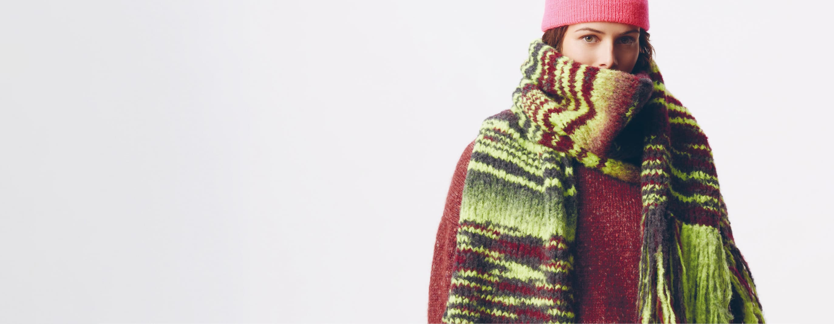 Frau trägt Strickschal mit Streifenprint. 