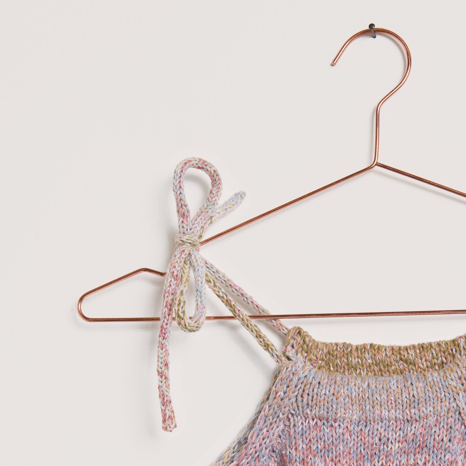 Made by Me No. 22 Frühjahr-Sommer: Stricktop in Pastelltönen auf kupferfarbenem Bügel.