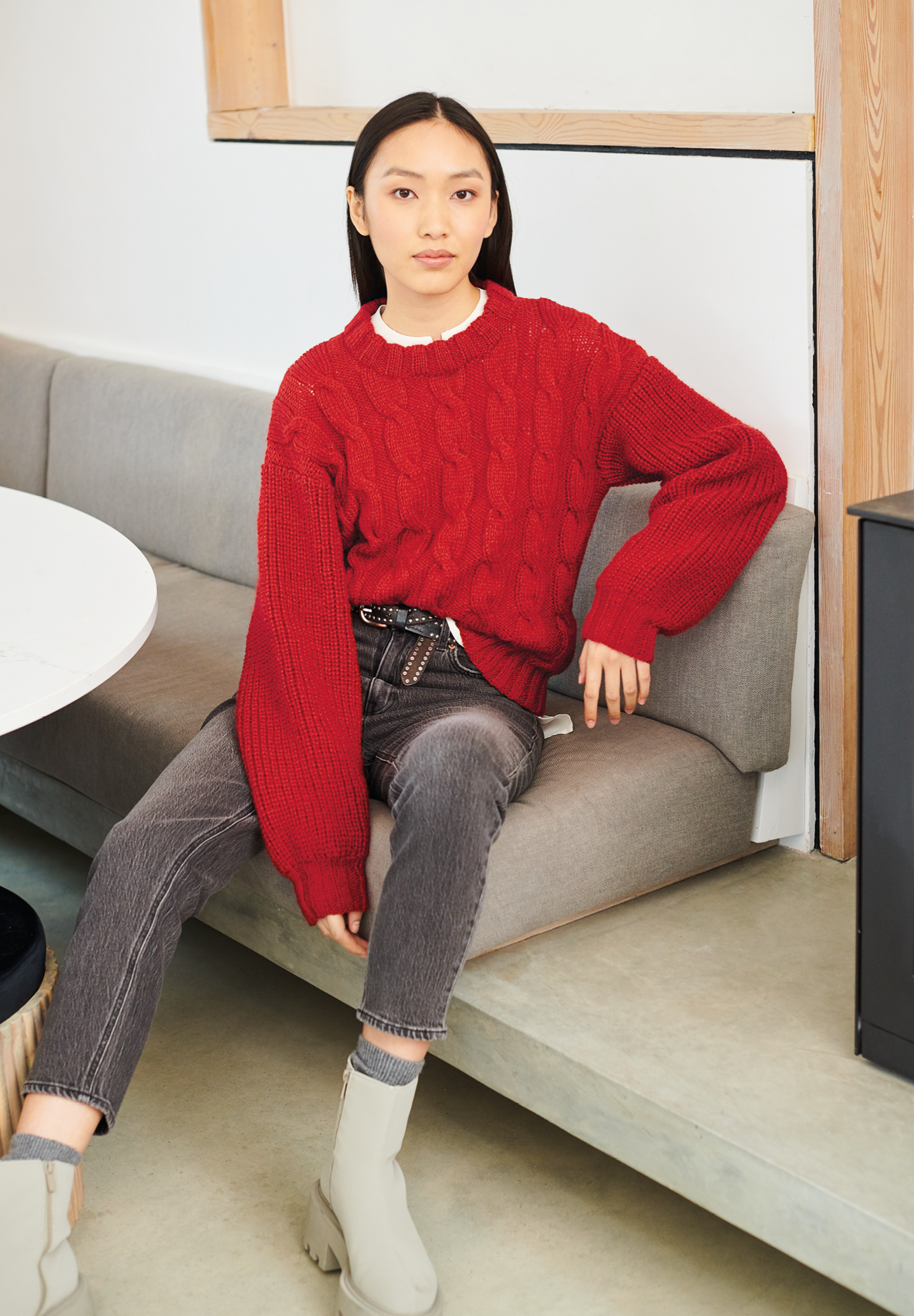 Frau trägt gestrickten Pullover in Rot: Modell 23 aus Lovewool No. 19