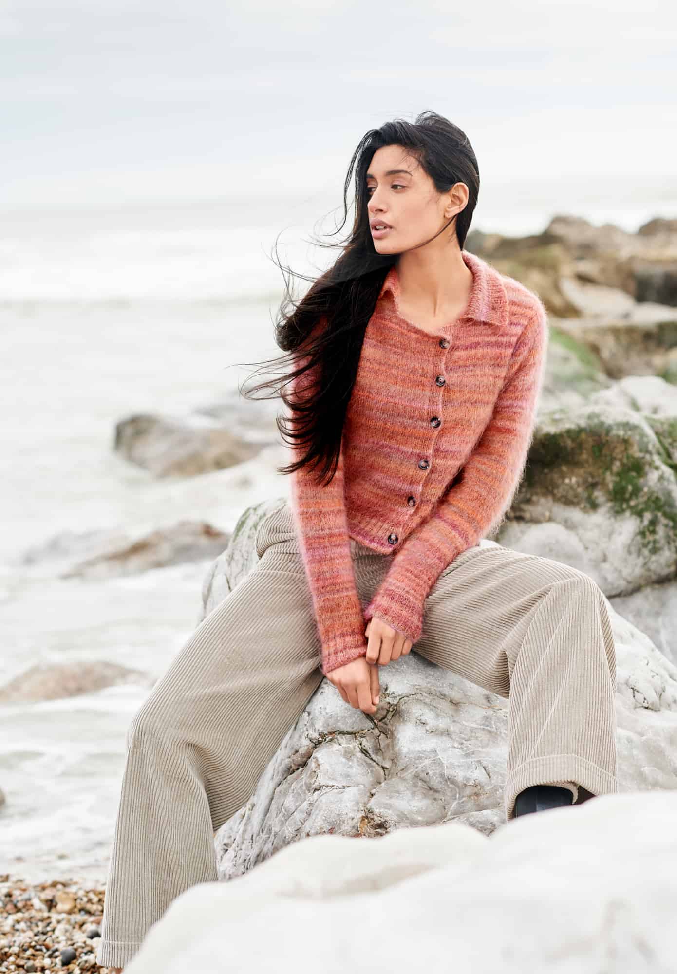 Frau trägt gestrickte Jacke mit Kragen und Knopfleiste in Orangetönen: Modell 40 aus Lovewool No. 21