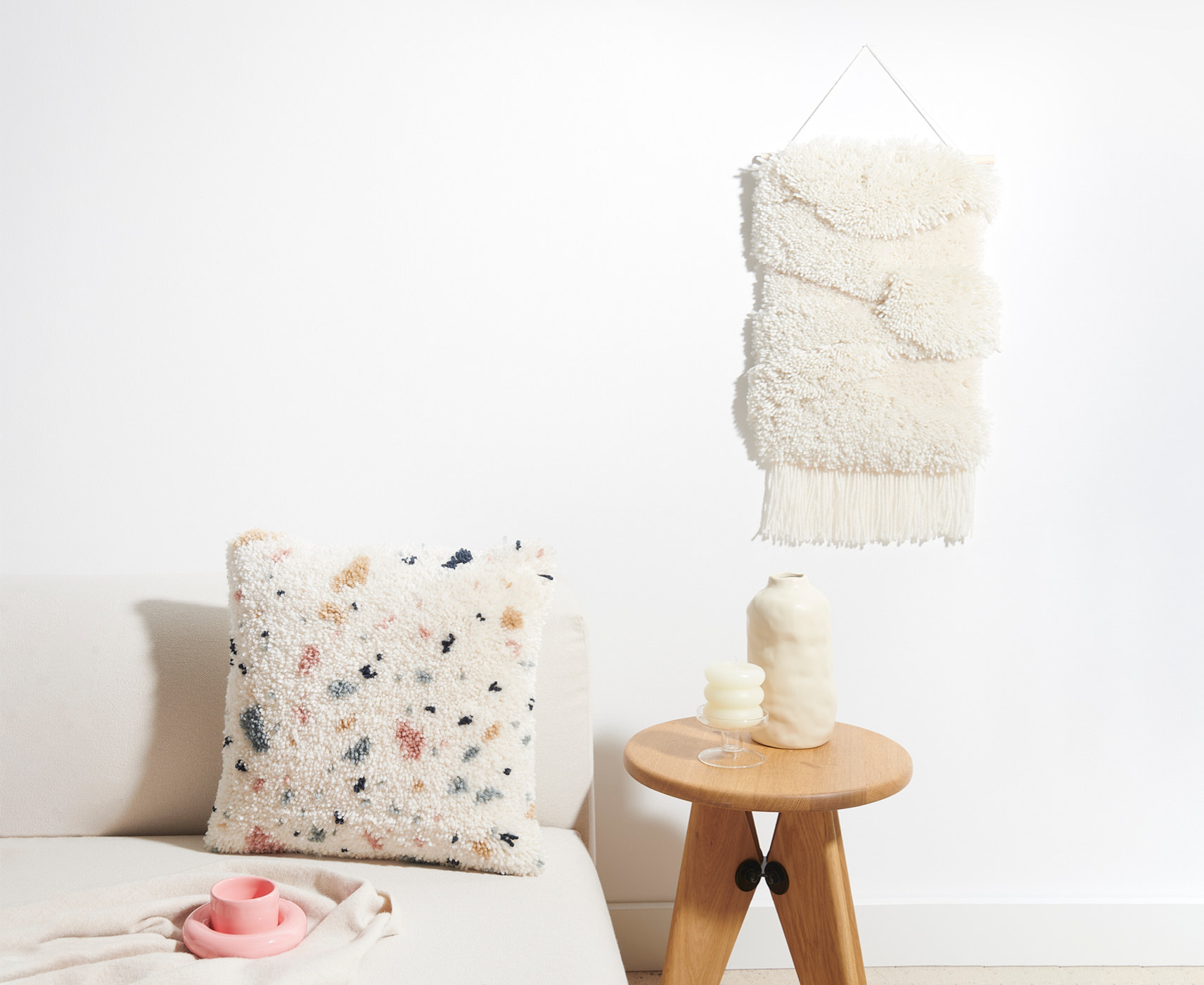 Geknüpfte Wandbehänge und Kissen in wohnlicher Kulisse