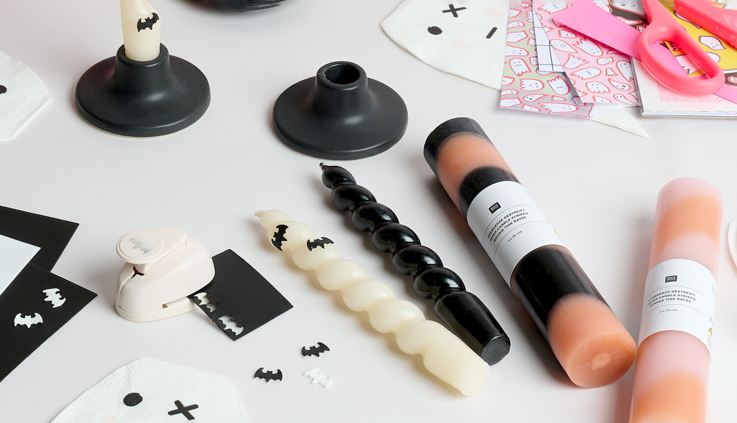 Anleitung Halloween-Kerzen verzieren mit DIY-Bastelset, Stabkerzen in Hellorange, Schwarz und Weiß, Papiermotiven, Stanzer und Deko-Fledermäusen