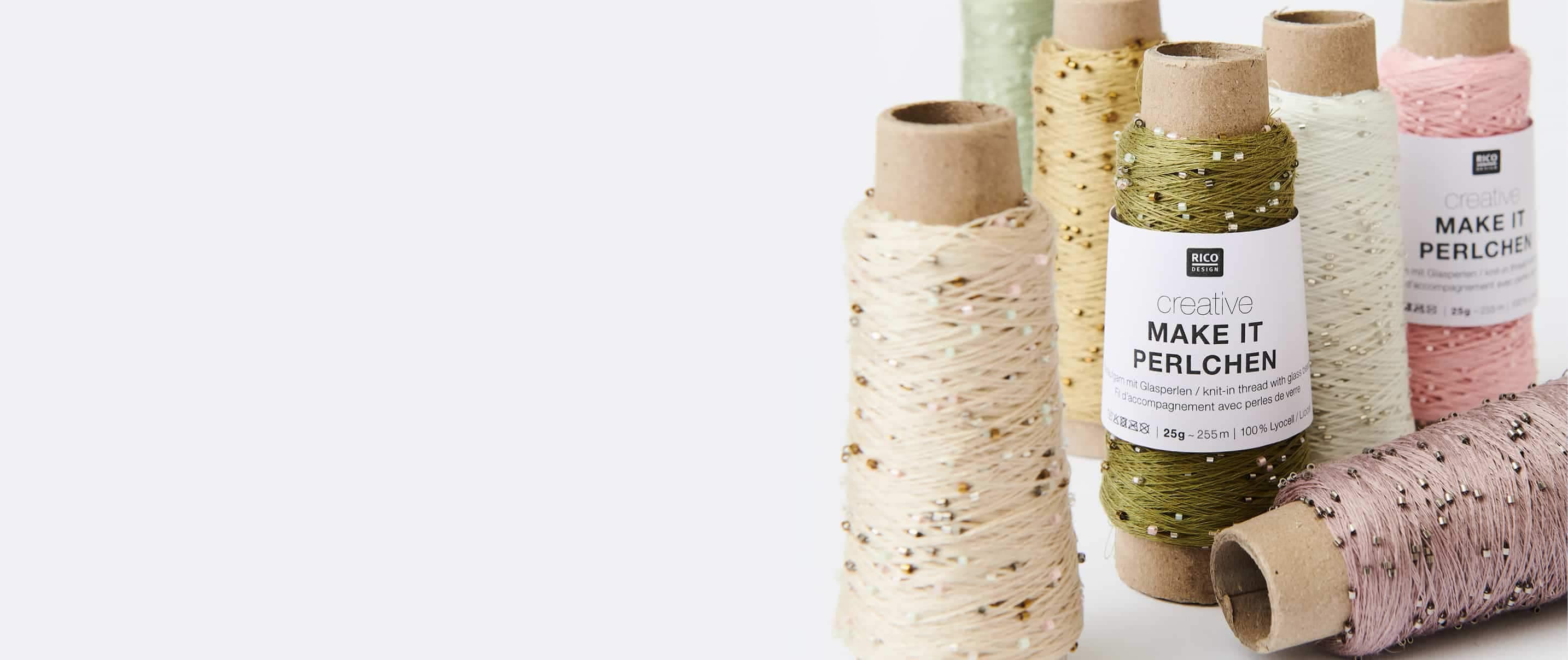 Verschiedene Garnrollen von Creative Make it Perlchen sind beisammen aufgestellt.