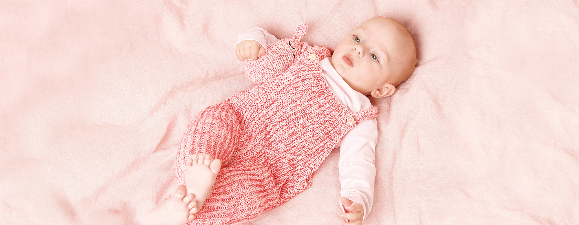 Baby mit gestricktem Strampler