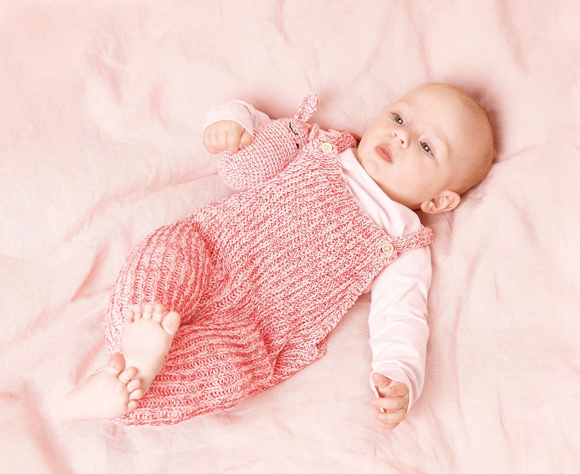 Baby mit gestricktem Strampler