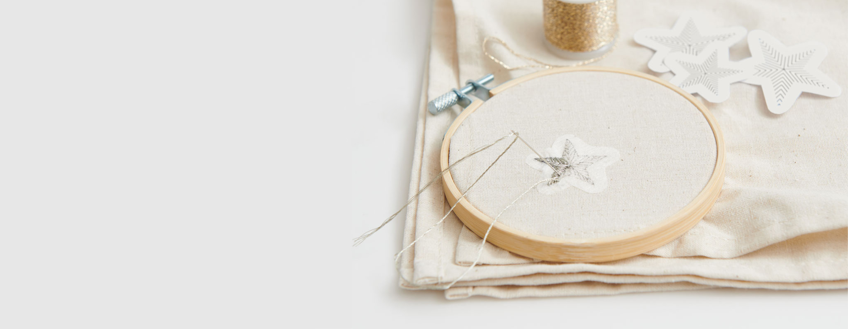 Ein Stick & Stitch-Aufkleber in Sternform klebt auf einem Stoff und wird bestickt.