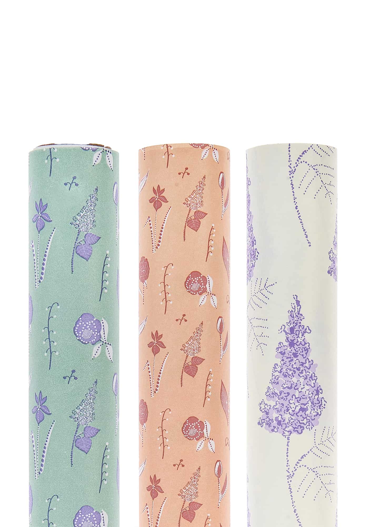 Drei Geschenkpapierrollen mit floralen Motiven.