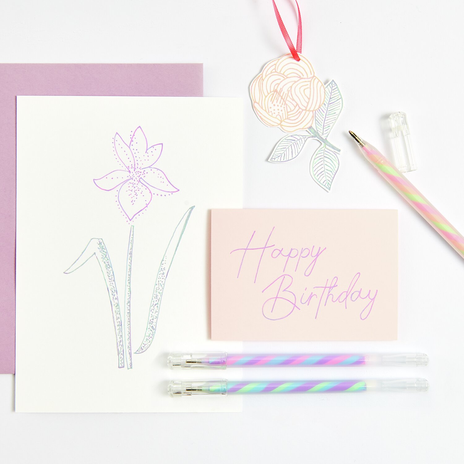 Gelstift Neon-Twist, 0,8mm: Zwei bunte Gelstifte auf einem Tisch mit Geburtstagskarte und Blumenmotiv.