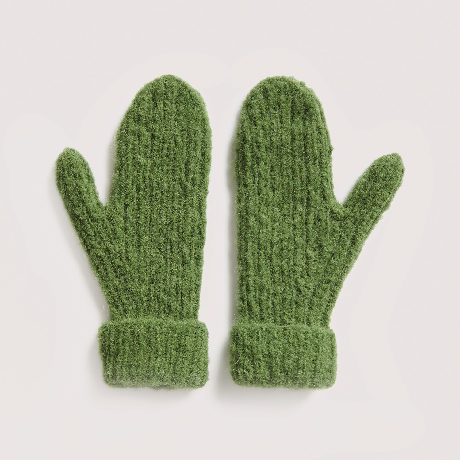Luxury Knits - Premium Natural Fibres Sprachauswahl deutsch von Rico Design Strickset Handschuhe Modell 20 aus Luxury Knits: Grüne Fäustlinge aus Premium Natural Fibres auf hellem Hintergrund.