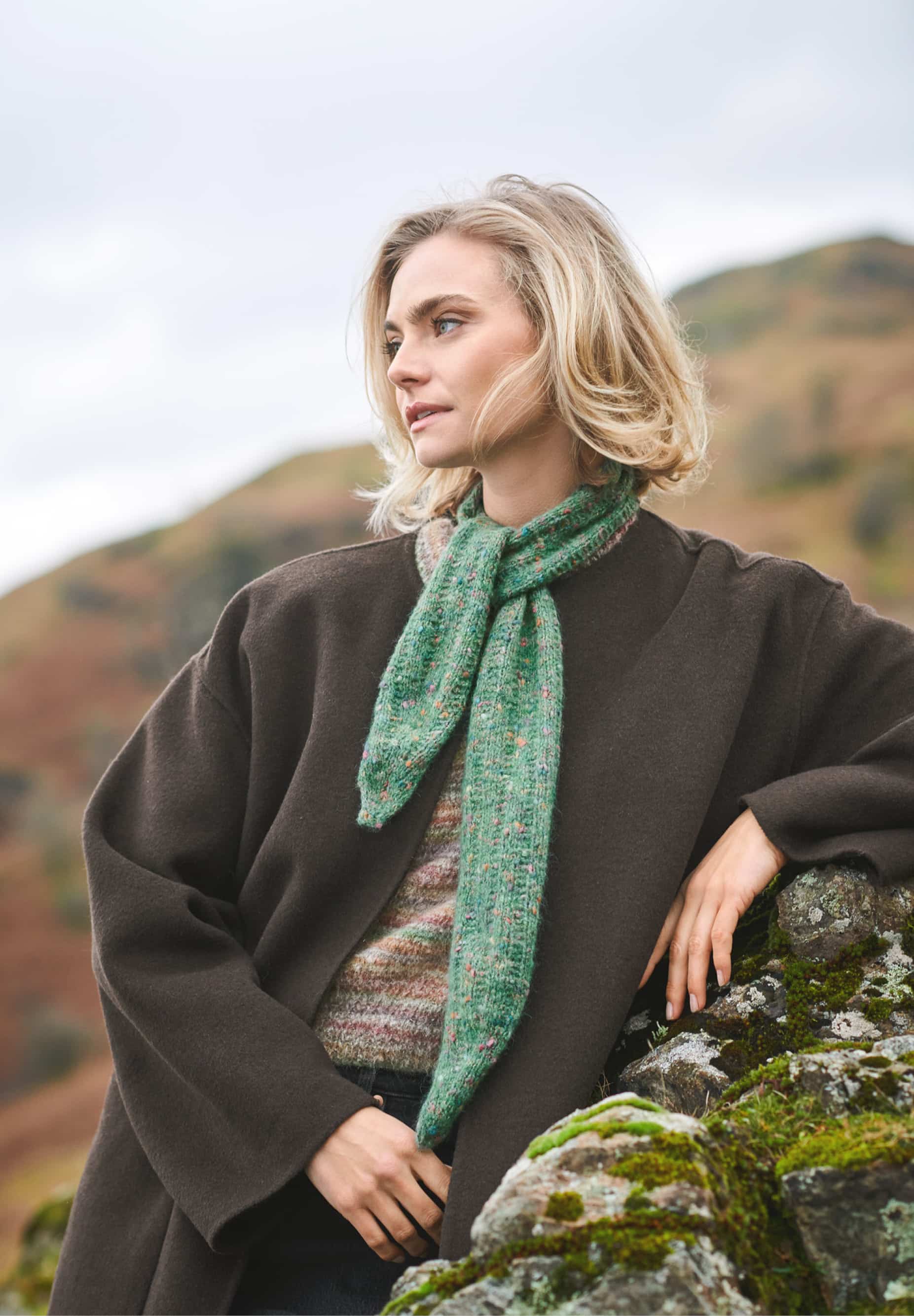 Frau trägt gestricktes Tuch in Grün: Modell 11 aus Lovewool No. 23