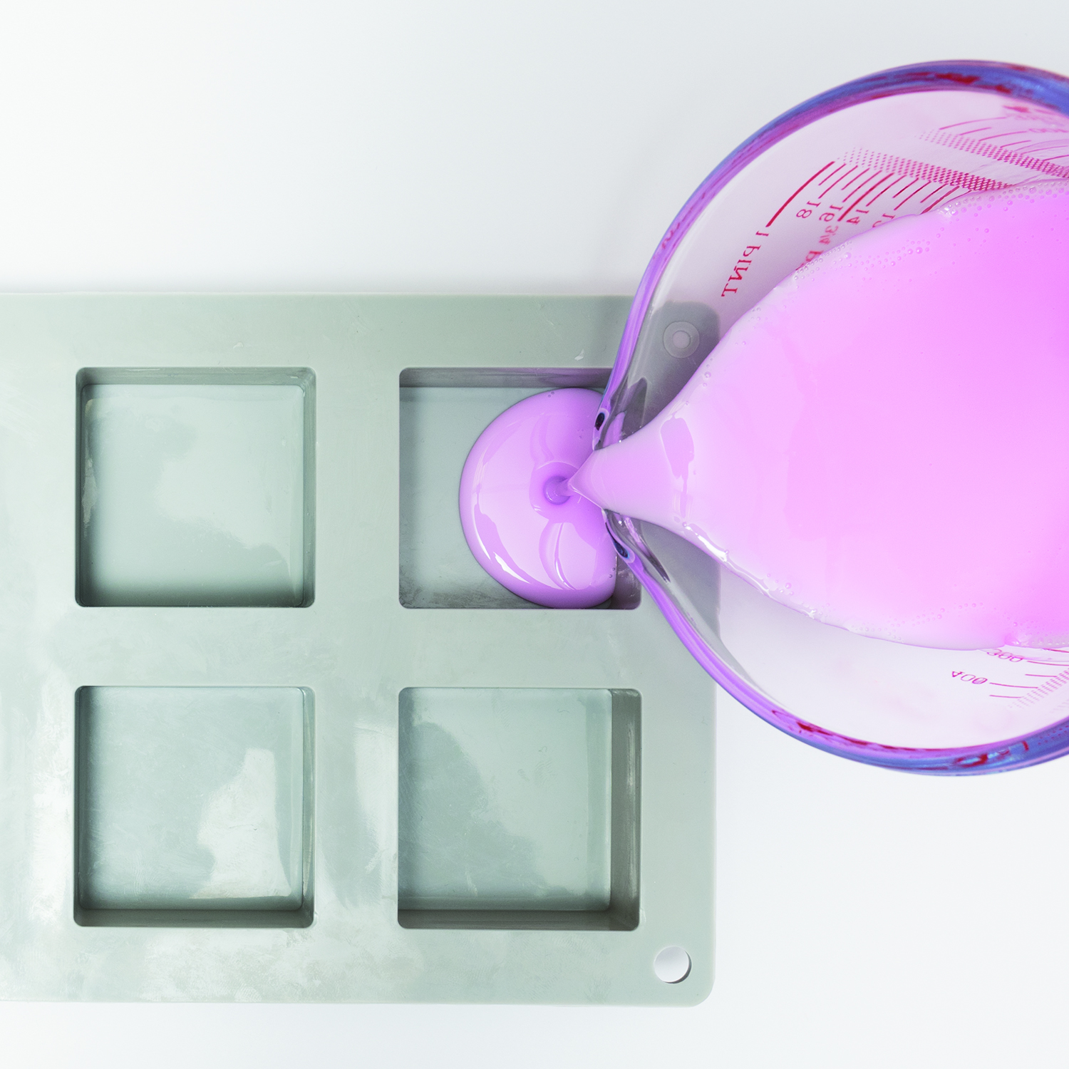 Geschmolzene rosa Seifenmaße wird in eine Gießform gegeben