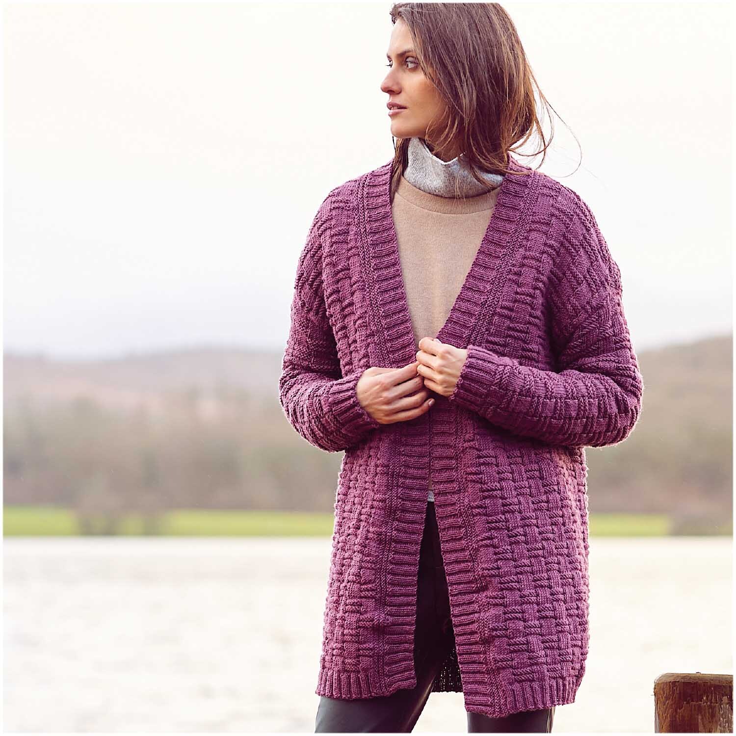 Essentials Merino dk Strickjacke in Magenta von Rico Design, getragen von Frau am Seeufer.