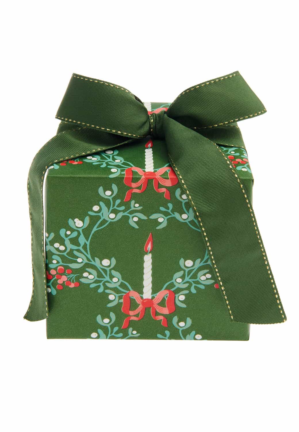Ein Geschenk ist in Geschenkpapier mit weihnachtlichen Motiven von Kerzen und Mistelzweigen eingepackt.