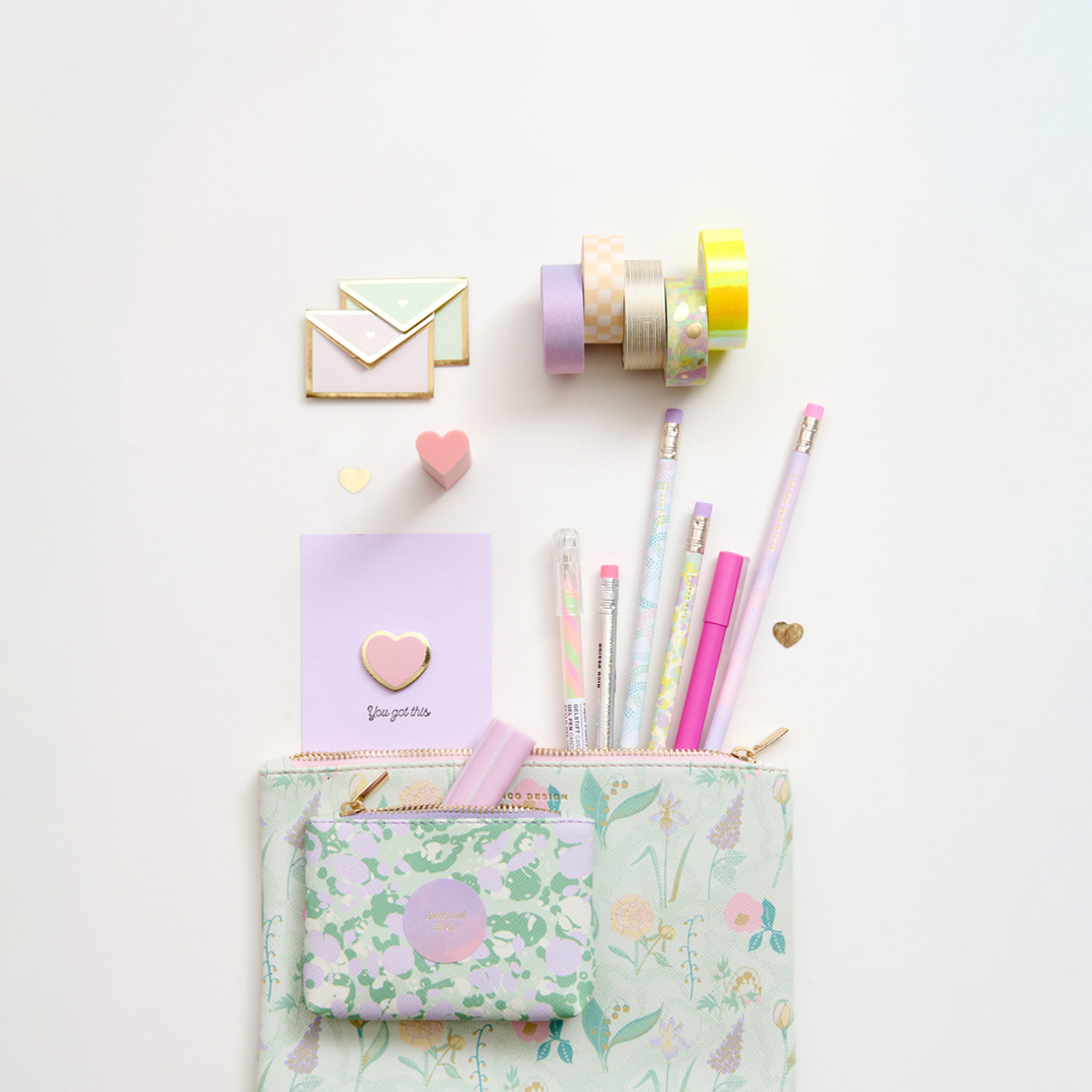 Zwei Etuis in verschiedenen Größen liegen übereinander auf grauem Hintergrund. Tapes, Stifte und Umschläge ragen aus den Etuis heraus.