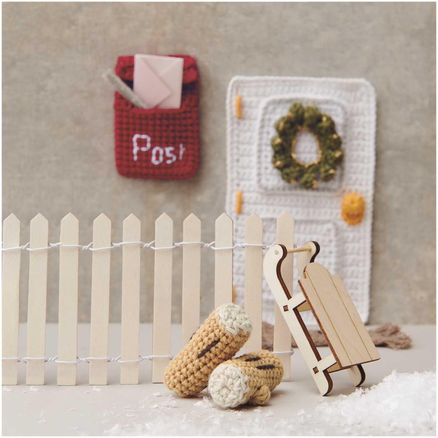 Creative Ricorumi dk: Handgefertigte Häkeldeko mit Schlitten und Zaun, ideal für winterliche Szenen.