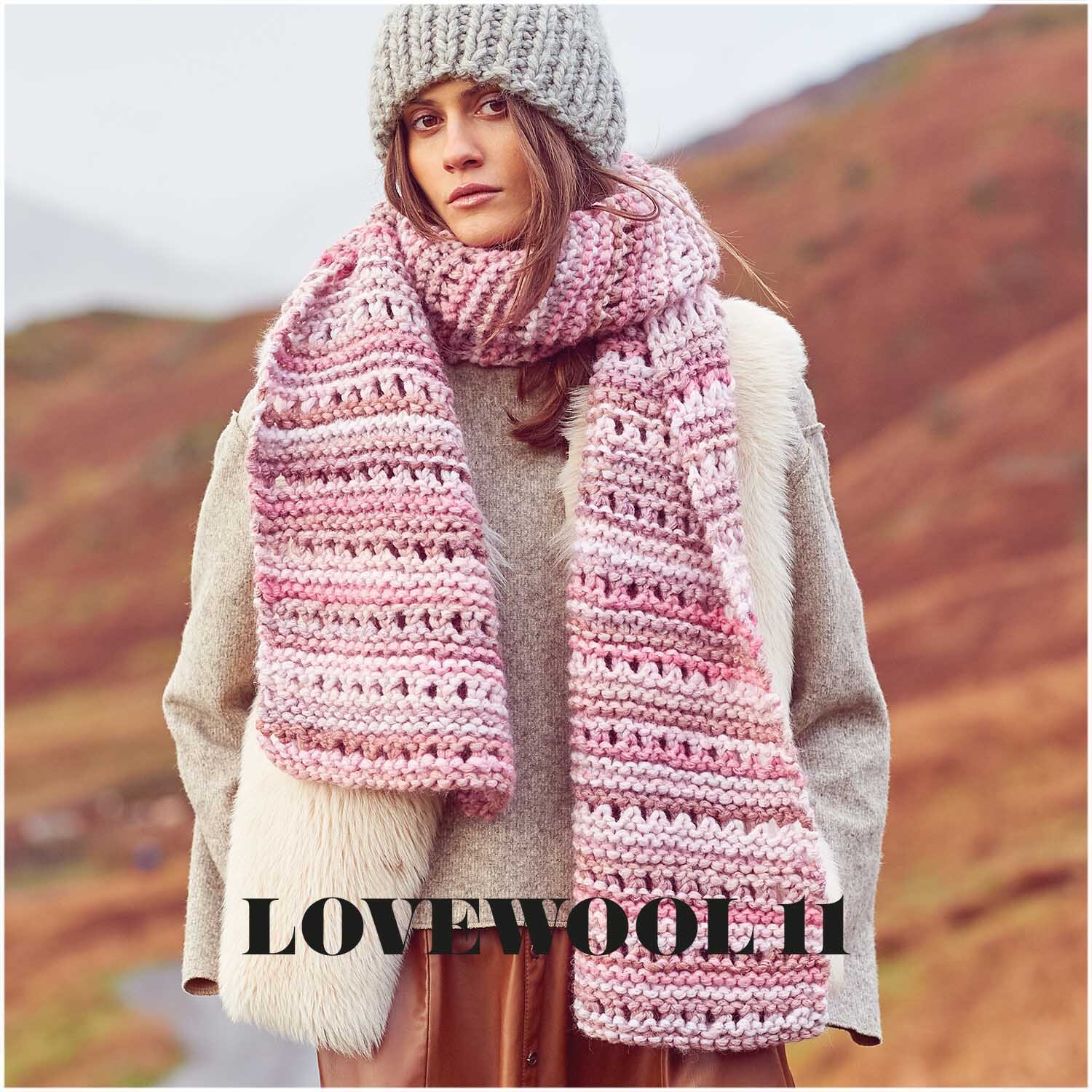 Creative Smile: Frau trägt gestrickten Schal in Rosa von Rico Design, umgeben von herbstlicher Landschaft.