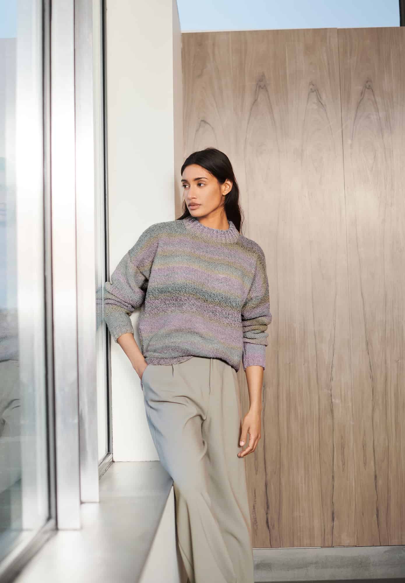 Frau trägt gestrickten Pullover mit Farbverlauf in Pastelltönen: Modell 20 aus Lovewool No. 21
